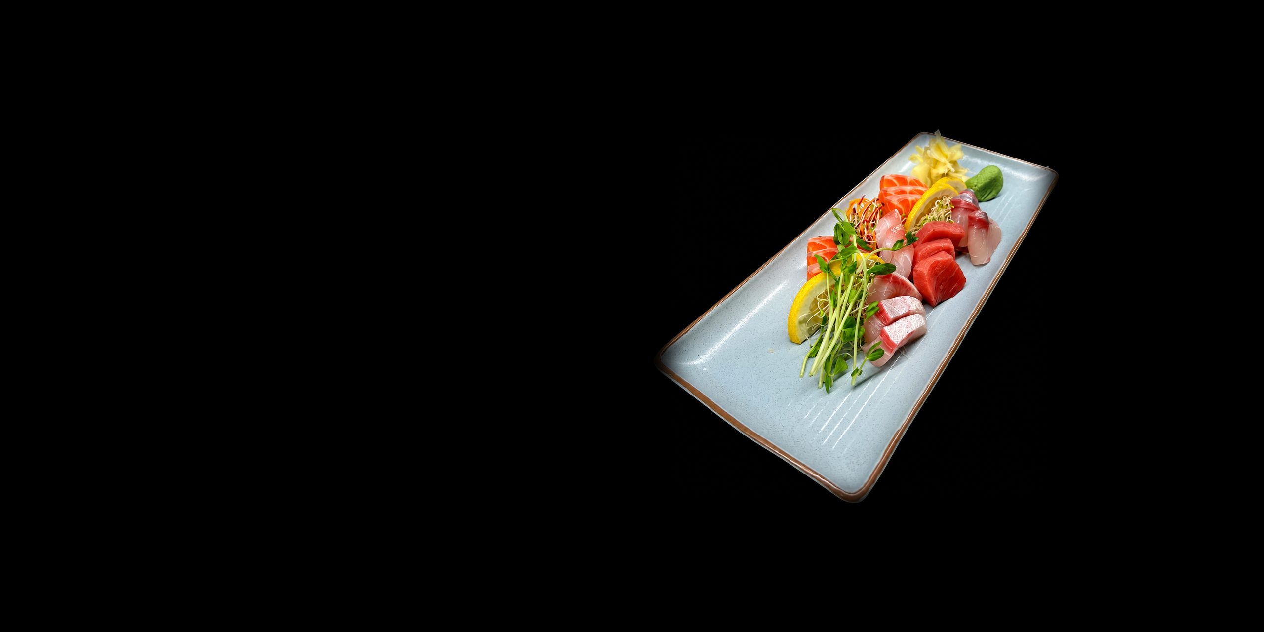 Assorted sashimi with lemon and pea shoots